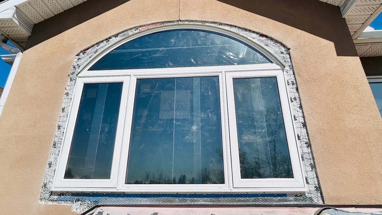New arched window being set and shimmed in rough opening during Calgary window replacement