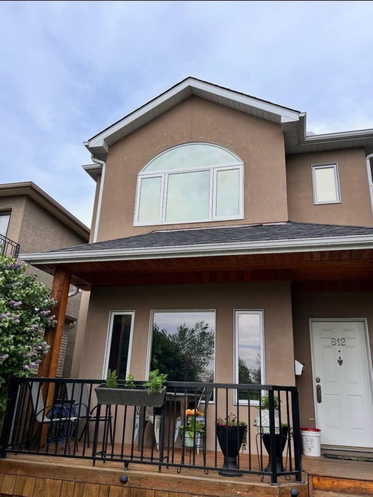Completed arched window replacement with full stucco repair on Calgary home exterior — High End Construction