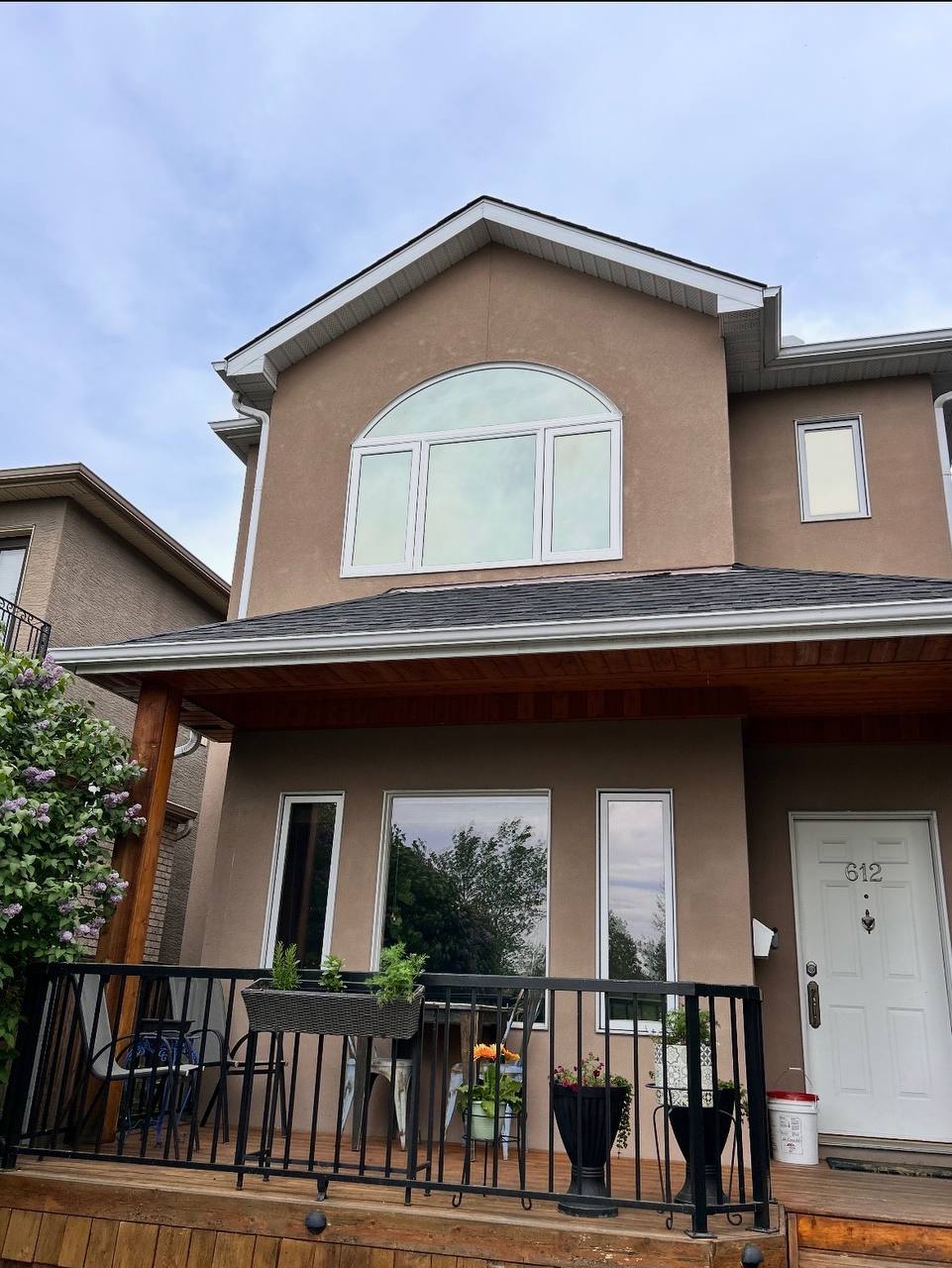 Completed arched window replacement with full stucco repair on Calgary home exterior — High End Construction