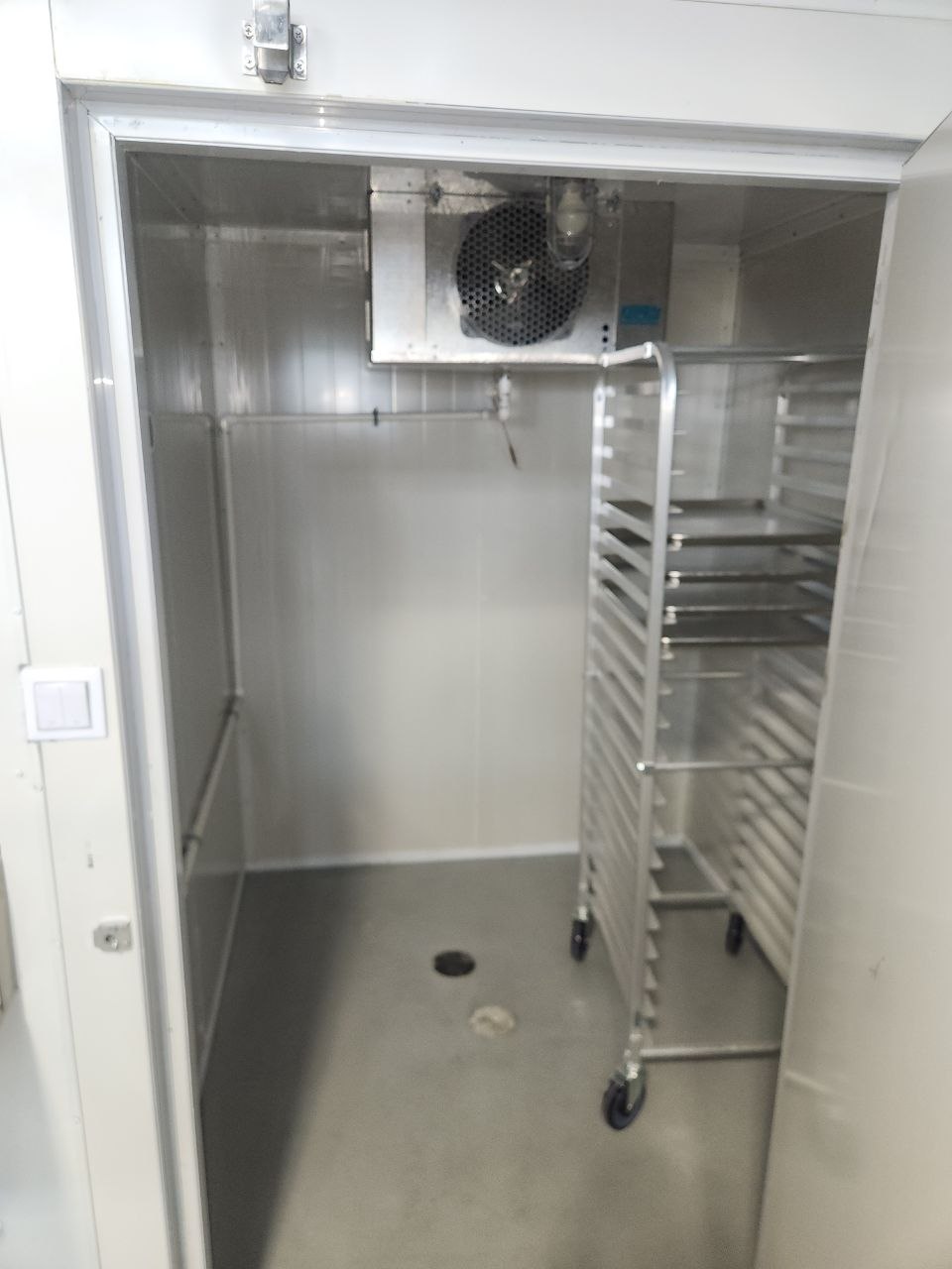 Commercial bakery cold storage room with refrigeration equipment and floor drain
