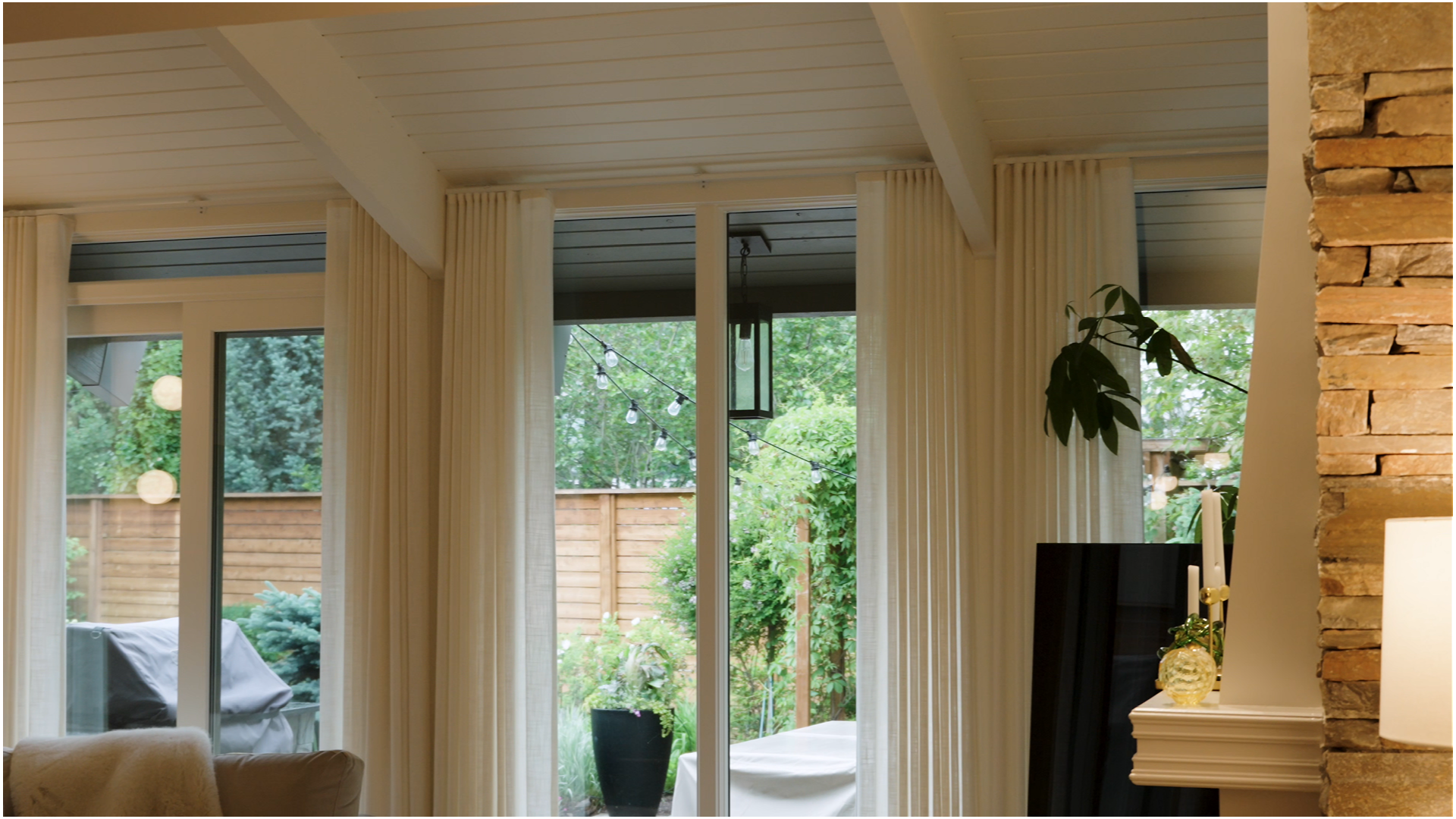 Fresh white-painted ceiling and trim beside a natural stone fireplace wall.