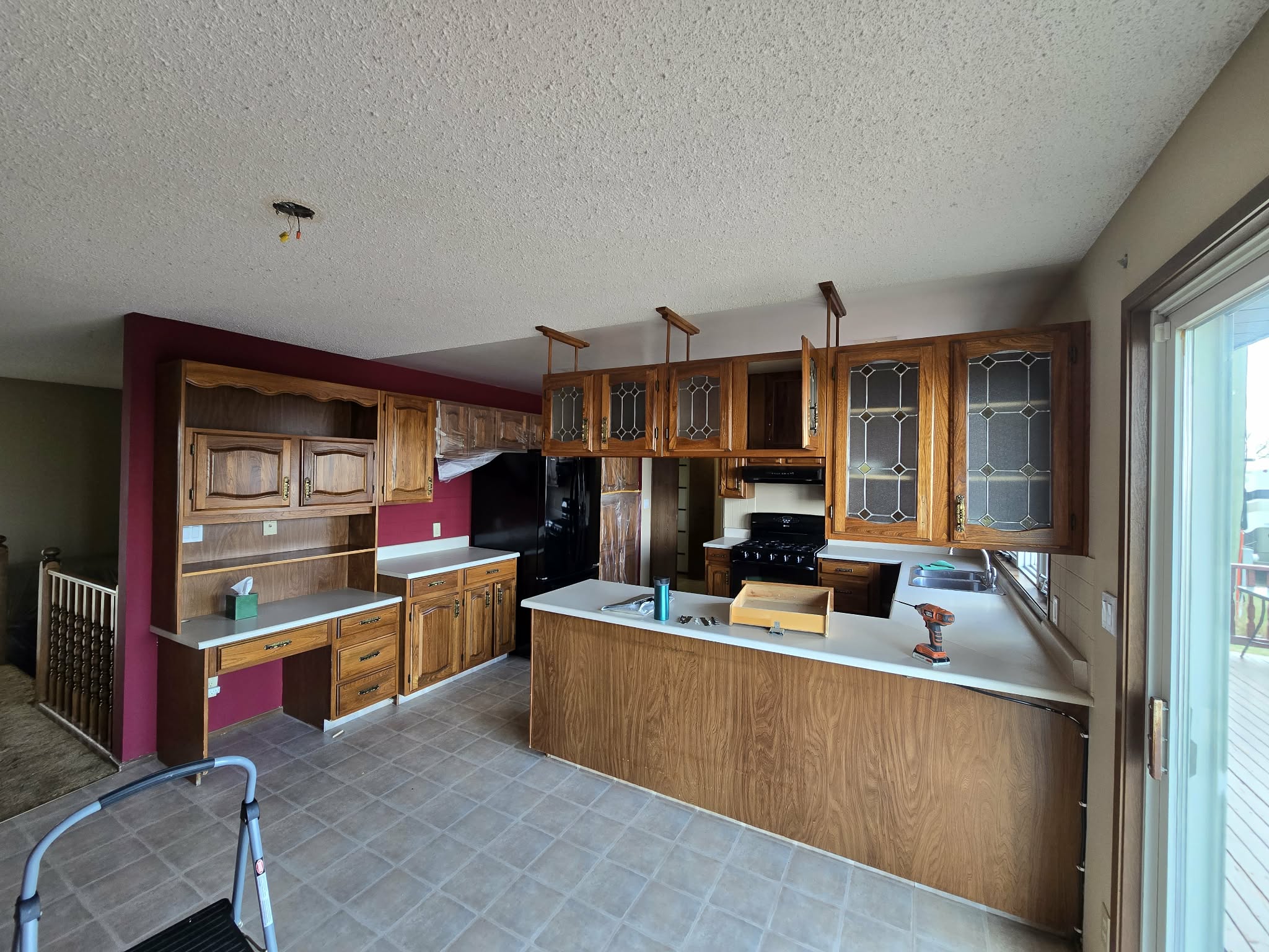 Kitchen during early renovation work with original patterned flooring and protected work areas