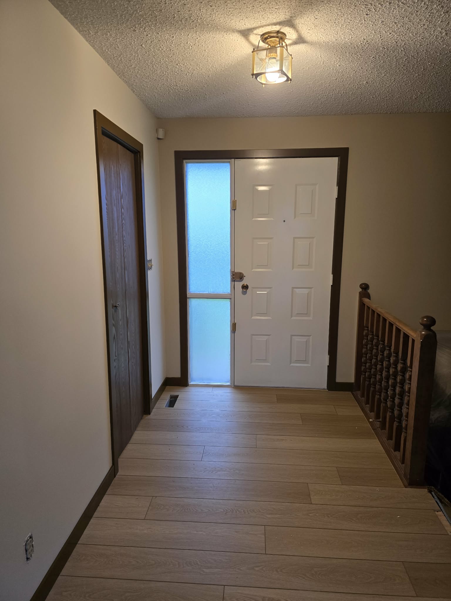 Entry renovation progress with light flooring, painted walls and dark trim