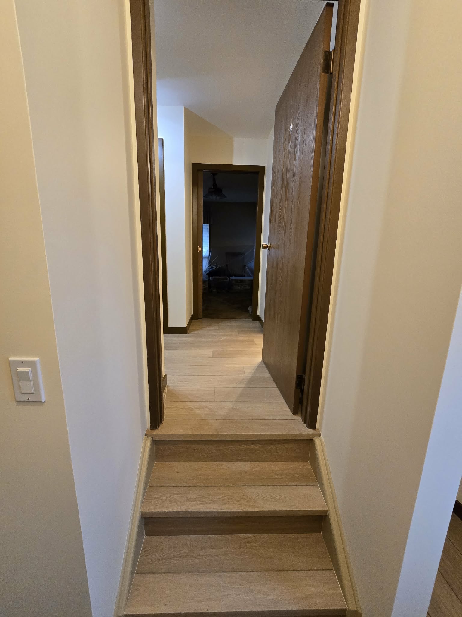Stairs and hall renovation progress with continuous light flooring and painted walls